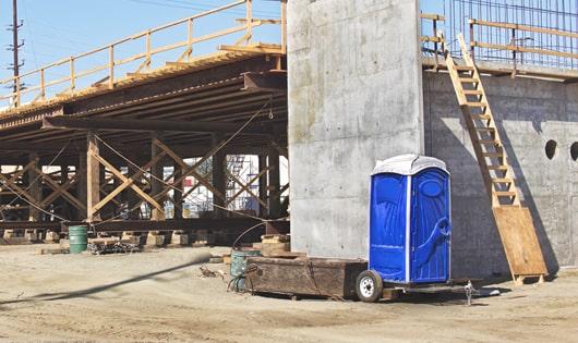 portable toilets lined up neatly, ready to serve work site workers